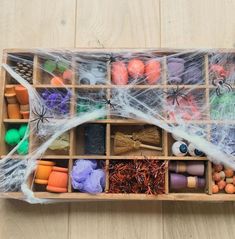 a wooden box filled with lots of different types of crafting supplies on top of a table