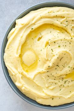 a blue bowl filled with mashed potatoes on top of a table