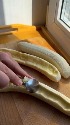 a person using a spoon to peel bananas