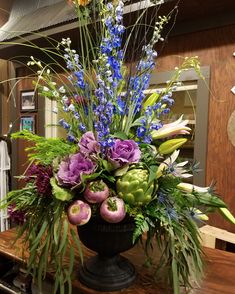 a vase filled with flowers on top of a wooden table