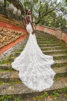 a woman in a wedding dress standing on some steps