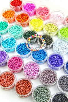 there are many different colors of beads on the table