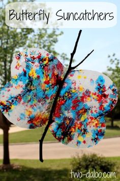 a paper plate butterfly suncather hanging from a tree