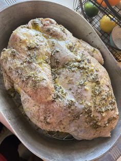 a chicken in a pan with herbs on it