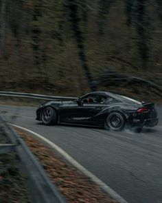 a black sports car driving down the road