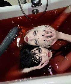 two people in a bathtub with blood all over them