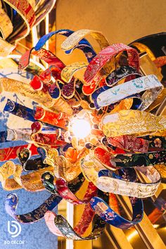 a chandelier with many different colored ribbons hanging from it's centerpiece