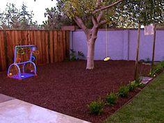 a backyard with a swing set and tree