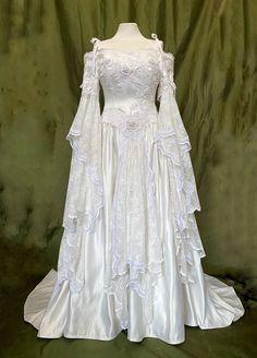 a white wedding gown with long sleeves on display