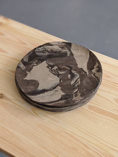 a wooden table topped with a black and white plate on top of it's surface