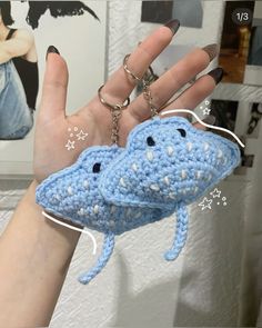 a hand holding a crocheted keychain in the shape of a shark