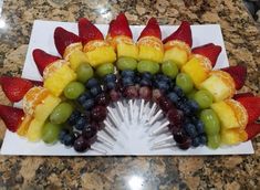 a plate with fruit arranged in the shape of a rainbow