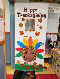 a door decorated to look like a turkey with leaves on it and the words happy thanksgiving