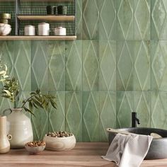 a kitchen counter with pots and bowls on it next to a shelf filled with plants