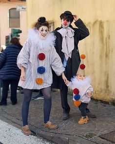 two people dressed in clown costumes walking down the street