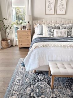 a bedroom with a large bed and rugs on the floor