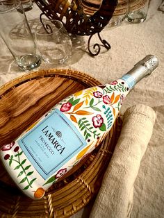 an empty bottle sitting on top of a table next to some glasses and napkins