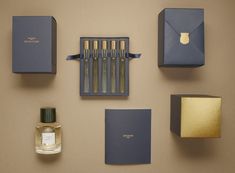 an assortment of perfumes and boxes on a wall with one opened in the middle