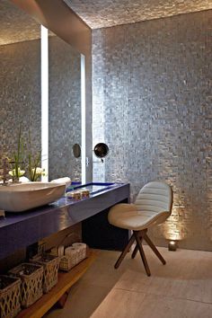 a bathroom with two sinks and a mirror on the wall next to a chair in front of it