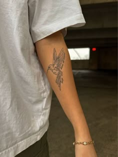 a person with a bird tattoo on their arm