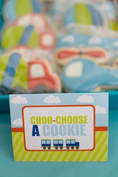 a close up of a plate of cookies on a table with a sign that says choo - choose a cookie