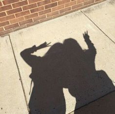 a shadow of a person on the sidewalk with a skateboard in front of them