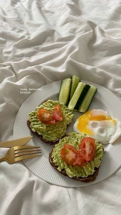 an open face sandwich topped with avocado and tomatoes