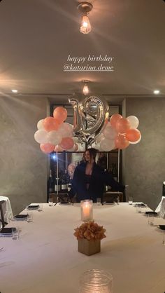 a woman is sitting at a table with balloons