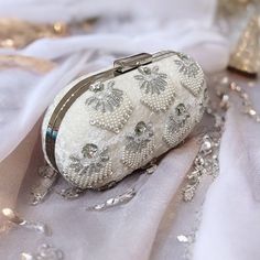 Introducing our exquisite white oval clutch, adorned with meticulous beadwork, shimmering sequins, and delicate crystal embellishments. Crafted with precision and care, this clutch exudes elegance and sophistication. Its high-quality thick chain adds a touch of glamour, while the suede lining ensures luxurious comfort. Made with premium velvet, this clutch is not just a statement accessory but a timeless piece of artistry. Elevate your ensemble with this stunning blend of craftsmanship and style Pearl Work, Bridal Clutch, Beaded Clutch, Ivory Wedding, Evening Clutch, Crystal Embellishment, White Beads, Timeless Pieces, Evening Bags