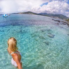 a woman is standing in the clear blue water