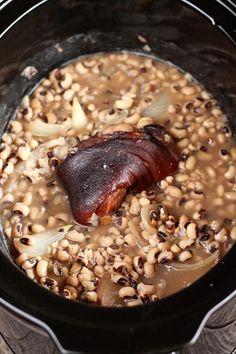 a bowl filled with beans and meat on top of a table