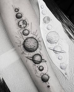 an arm tattoo with planets on it