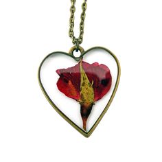 A single rose for the perfect gift for the unique gal in your life.  A rose is encased in jewelry grade resin, within an antique bronze or gold plated heart bezel.  The bezel is 1 1/2 inches in length and 1 1/4 inches in width- the matching chain is 24 inches.   Chain is finished with a lobster clasp.  Necklace will arrive attached to card shown in photos. Ready to be gifted! This necklace is custom made. Just like nature, no two will be exactly alike! Let me assure you, though, that we replicat