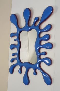 a mirror with blue paint on it in the shape of a flower