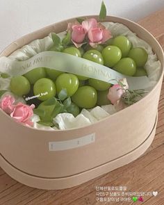 a box with some green olives and flowers in it