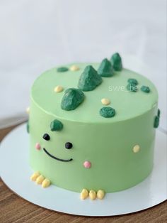 there is a green cake that looks like it has been decorated with rocks and leaves