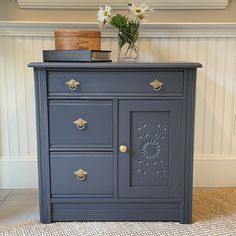 a blue dresser with some flowers on top