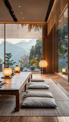 a room with wooden flooring and large windows overlooking the mountain range in front of it