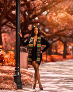 a woman is standing next to a lamp post