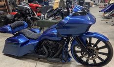 a blue motorcycle parked in a garage next to other motorcycles