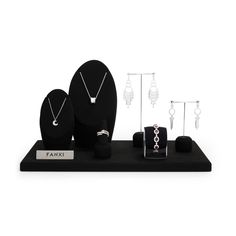 an assortment of jewelry is displayed on a black stand