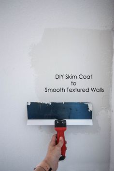 someone using a paint roller to paint the wall