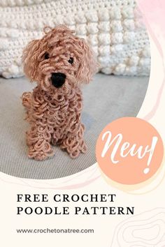 a crochet dog sitting on top of a bed next to a white blanket