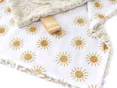 a blanket with gold sun print on it and a ring laying on top of it