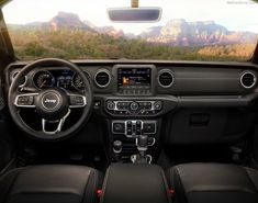 the interior of a jeep with mountains in the background