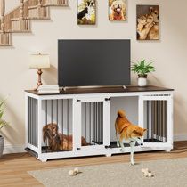 two dogs are in their kennels looking at the television on top of the entertainment center