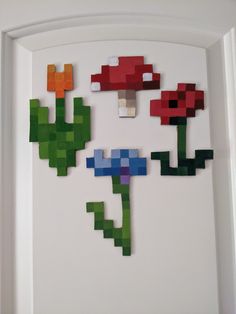 an art piece made out of legos with flowers and leaves on the bottom half