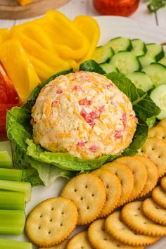 a plate with crackers, cheese and vegetables on it