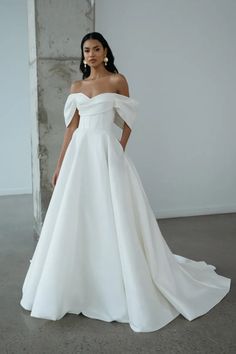 a woman in a white wedding dress posing for the camera