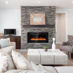 a living room with a fire place and couches in front of the fireplace,